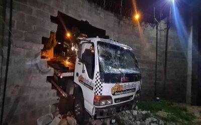 Caminhão-guincho perde os freios, bate em muro e invade barracão